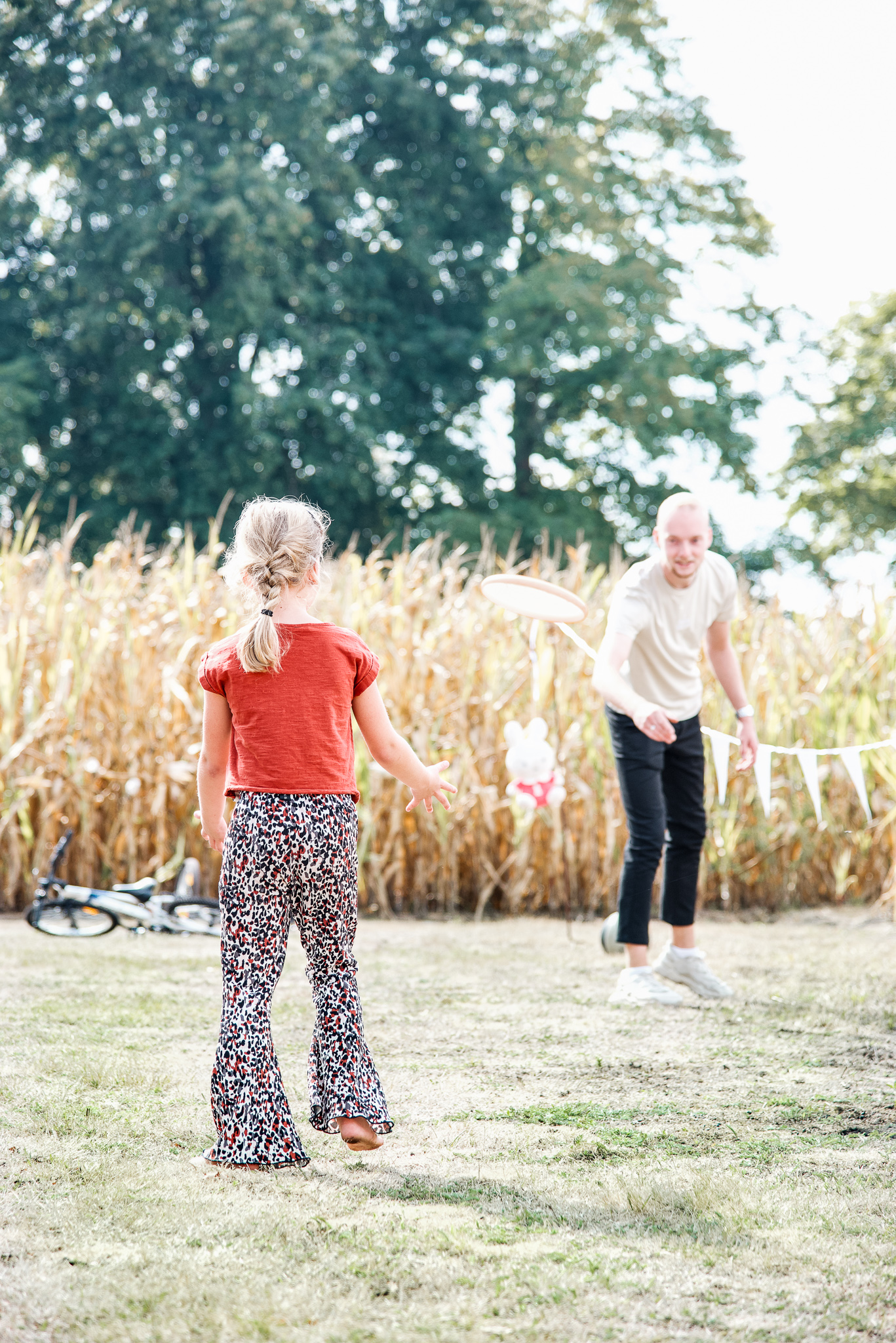 Twee meisjes spelen samen op het grasveld voor het maisveld