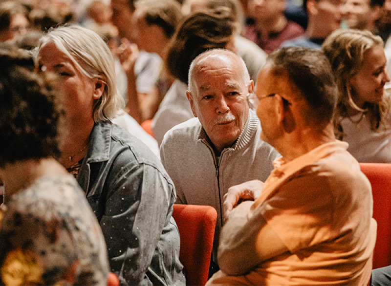 Bezoekers in gesprek in de zaal voorafgaand aan een samenkomst
