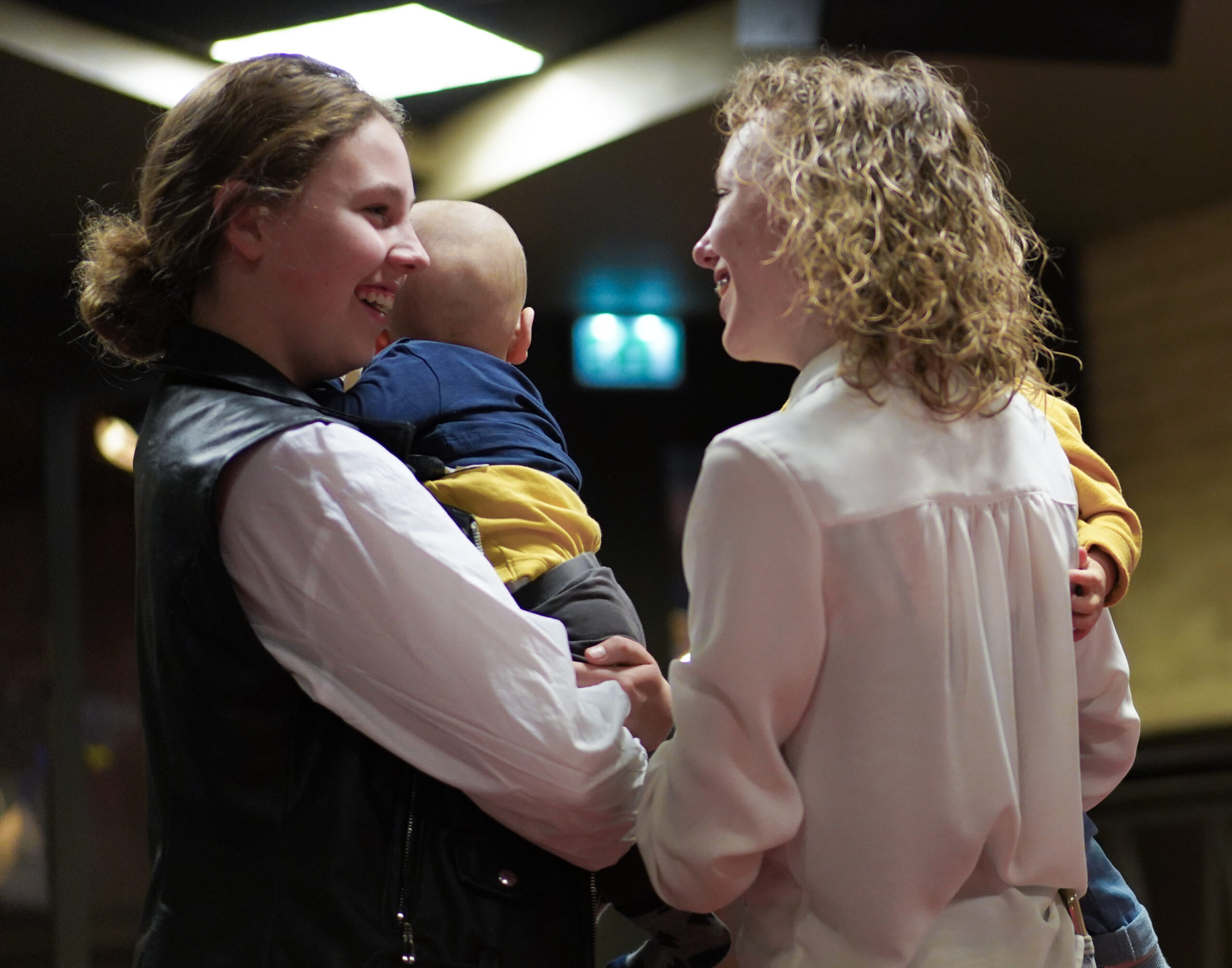 Twee vrouwen praten met elkaar terwijl een van hen een baby op de arm heeft