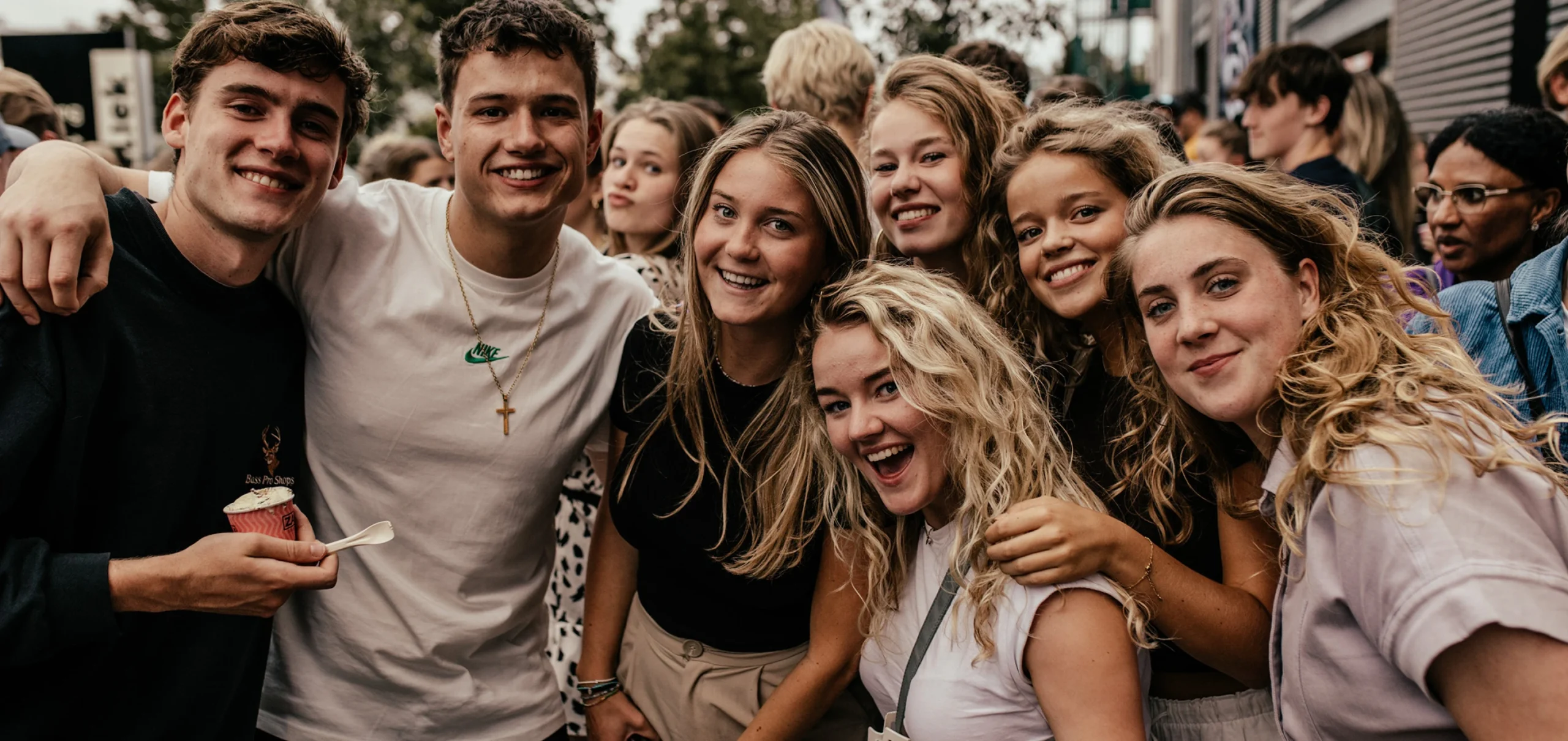 Groep jongeren met de armen om elkaar heen op de foto
